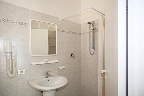 bagno con lavandino e specchio di Hotel Serafini a Misano Adriatico