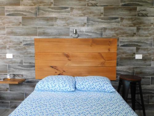 a bedroom with a bed and a wooden headboard at Zyan Rooms in Villahermosa