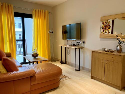 a living room with a couch and a flat screen tv at Forest View Apartments in Kololi
