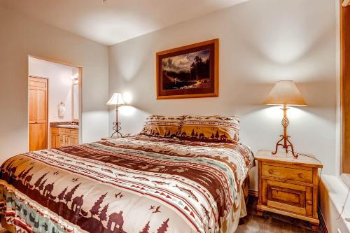 a bedroom with a bed and a table with a lamp at Corral at Breckenridge #103E - Private Hot Tub - Close to Town in Breckenridge