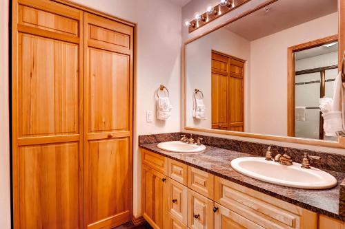 a bathroom with two sinks and a large mirror at Corral at Breckenridge #103E - Private Hot Tub - Close to Town in Breckenridge