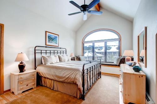 1 dormitorio con 1 cama, ventilador de techo y ventana en Mountaineer #M-1 - Ski-In/Ski-Out - Private Outdoor Hot Tub, en Breckenridge