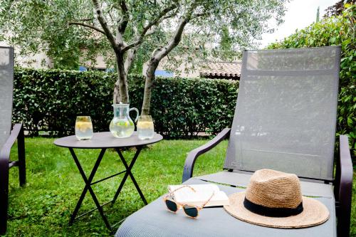 a hat and glasses sitting on a table with a chair at Le Mas de La Crémaillère in Gréoux-les-Bains
