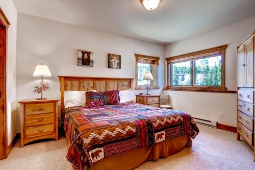 a bedroom with a bed and two windows at Saddlewood #46 Ski-In/Ski-Out to Snowflake Lift - Walk to Town in Breckenridge