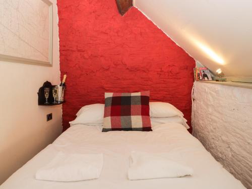 ピカリングにあるCherry Tree Cottageの赤い壁のベッドルーム1室(白いベッド1台付)