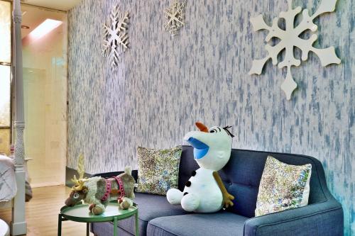 a living room with a blue couch with a snowman on it at Vogue Boutique Motel in Yangmei