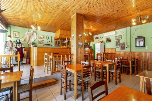 jadalnia z drewnianymi stołami i krzesłami w obiekcie Toti Boutique Rooms w Kalambace