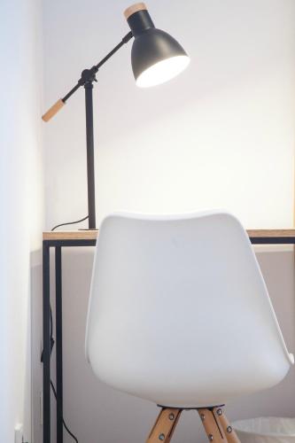 a white chair sitting next to a desk with a lamp at Pensión Sarriegi in Donostia-San Sebastián