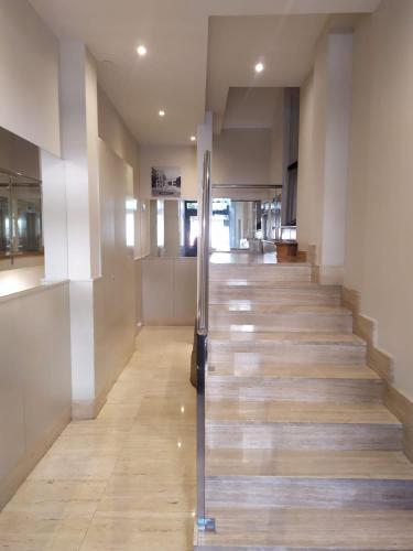 a staircase in a building with a metal hand rail at Pensión Sarriegi in Donostia-San Sebastián