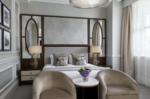 a bedroom with a bed with two chairs and a table at The Midland in Manchester