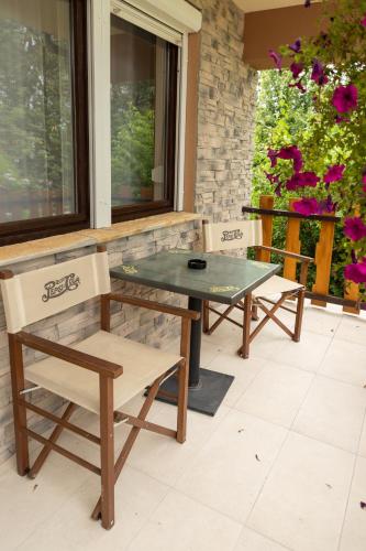 two chairs and a glass table on a patio at Fortuna Vendégház in Kiskunhalas