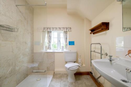 a bathroom with a toilet and a tub and a sink at Marris Cottage in Grimsby