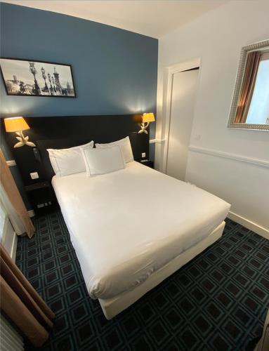 a bedroom with a large white bed in a room at Hôtel Etoile Trocadéro in Paris