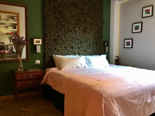 マドリードにあるApartment Olivarの緑の壁のベッドルーム1室(大型ベッド1台付)