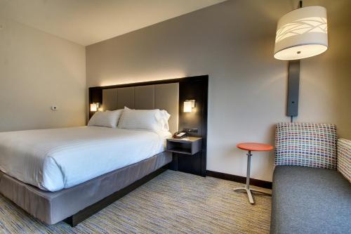 a hotel room with a bed and a chair at Holiday Inn Express & Suites Charleston NE Mt Pleasant US17 by IHG in Charleston