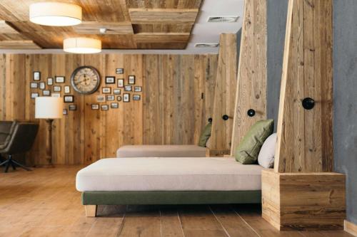 a bed in a room with wooden walls at Ruhehotel & Naturresort Rehbach - Adults only in Schattwald