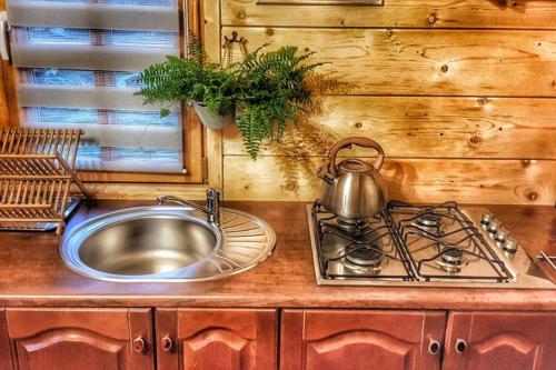 a kitchen with a sink and a pot on a stove at Domek Góralski Parzenica Jacuzzi zewnętrzne, Grill, Parking in Kościelisko