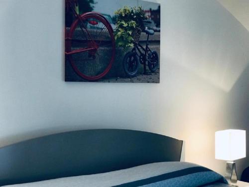 a painting of a bike hanging above a bed at Il Rifugio del Pescatore in Ponza