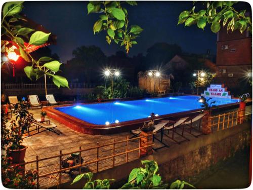 a large swimming pool at night with lights at Trang An Village Homestay in Ninh Binh