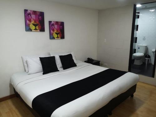 1 cama blanca y negra en una habitación en Hotel Santiago Plaza, en Bogotá