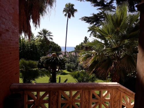 a view from the balcony of a resort with palm trees at Villa dei Marchesi Carrozza in Santa Teresa di Riva