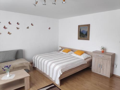 um quarto com uma cama e um sofá em Holiday Home Liptovský Peter em Liptovský Hrádok