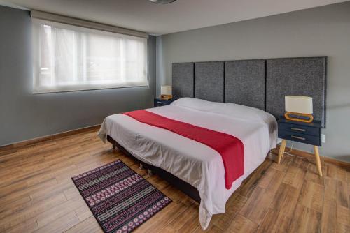 a bedroom with a large bed with a red blanket at Grupo Kings Suites - Horacio 1525 in Mexico City