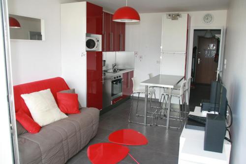 un salon avec un canapé et une cuisine dans l'établissement Votre hébergement au coeur des Deux Alpes, à Les Deux Alpes