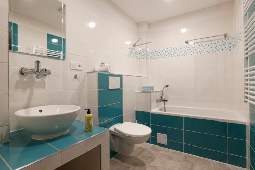 a bathroom with a sink and a toilet and a tub at Apartmány pod Mariánskými schody in Albrechtice v Jizerských horách