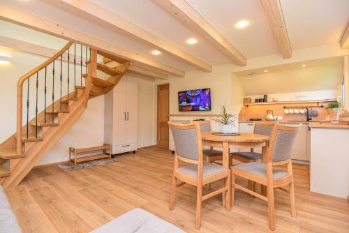 a kitchen and dining room with a wooden table and chairs at "Pamario Namelis" - Preiloje in Neringa