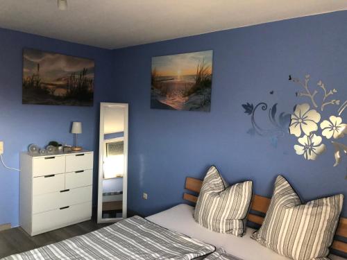 une chambre avec un lit et un mur bleu dans l'établissement Ferienwohnung Aueblick Kassel, à Cassel