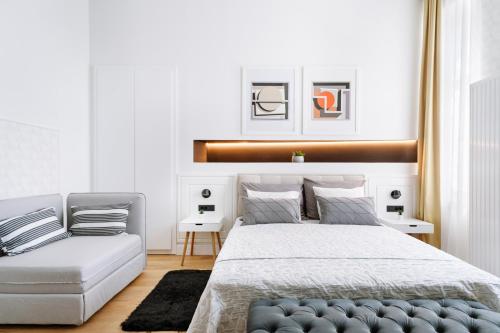 een slaapkamer met een bed en een bank bij THE City Lodge - Boutique Apartments in Zagreb