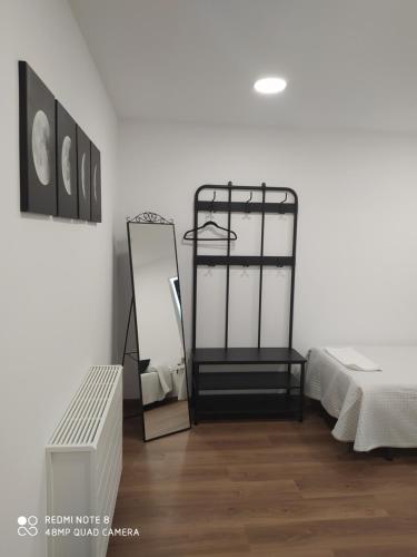 a room with a bed and a mirror on the wall at Huellas Albergue-Turístico in Portomarin