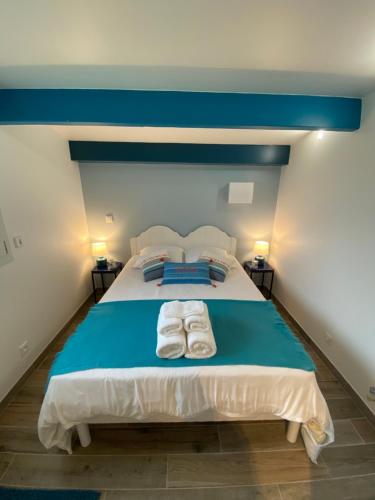 une chambre avec un lit avec deux serviettes dessus dans l'établissement Maisonnette de la mer, à Hermanville-sur-Mer