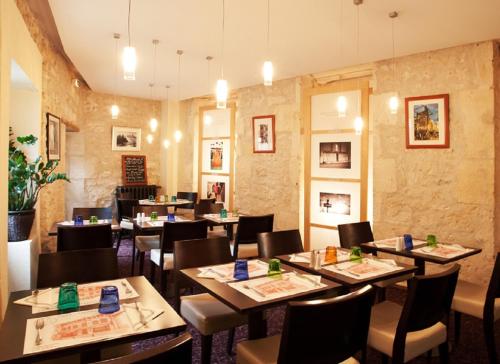 a restaurant with tables and chairs in a room at Hostellerie du Coq d'Or in Jonzac
