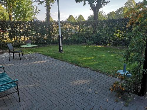 a patio with a table and a light pole in a yard at BenB Het Posthuis in Nispen