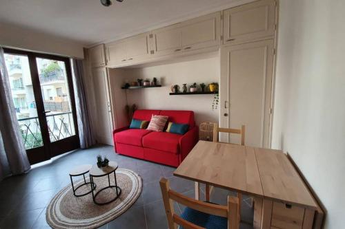 un salon avec un canapé rouge et une table dans l'établissement Studio cosy et calme, au cœur de Nice Libération, à Nice