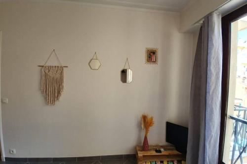 un salon avec un mur blanc avec trois lumières suspendues dans l'établissement Studio cosy et calme, au cœur de Nice Libération, à Nice