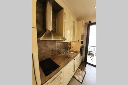 une cuisine avec un évier et une cuisinière dans l'établissement Studio cosy et calme, au cœur de Nice Libération, à Nice