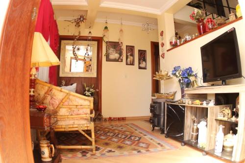 un soggiorno con un divano e una televisione di SCHUCH - POUSADA a Treze Tílias