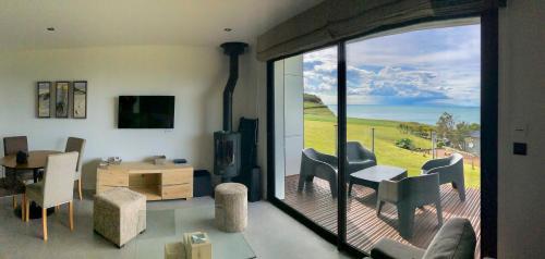 een woonkamer met een grote glazen schuifdeur bij Les Gîtes du Cap Cod in Varengeville-sur-Mer