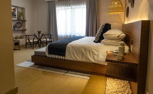 a bedroom with a bed and a dining room with a table at Agata Hotel Boutique & Spa in Mexico City
