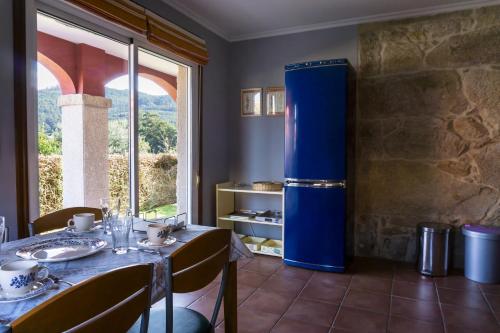 a blue refrigerator in a room with a table at Chalet en Canido in Vigo