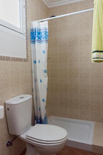 a bathroom with a toilet and a shower curtain at Chalet en Canido in Vigo