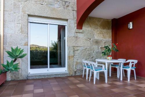 a patio with a table and chairs and a window at Chalet en Canido in Vigo