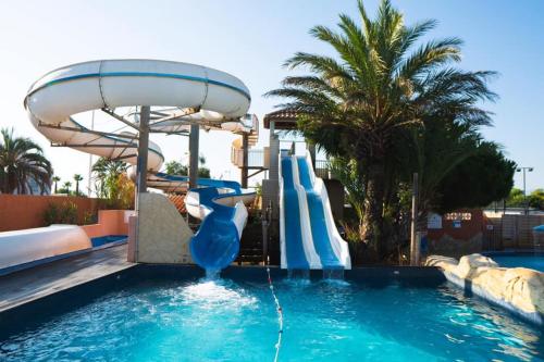 a pool with a water slide in a resort at Bungalow in Canet-en-Roussillon