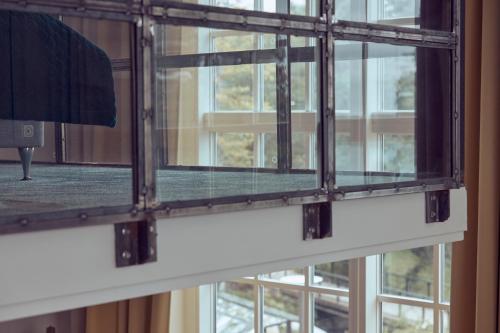 une fenêtre en verre avec vue sur un bâtiment dans l'établissement Nääs Fabriker Hotell & Restaurang, à Tollered