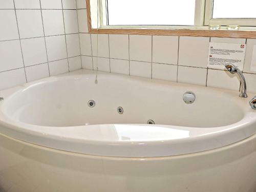 a bath tub in a bathroom with a window at 6 person holiday home in Ringk bing in Ringkøbing