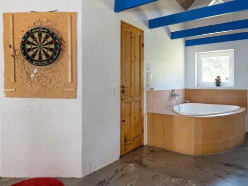 uma casa de banho com um alvo de dardos na parede e uma banheira em 16 person holiday home in Ulfborg em Ulfborg
