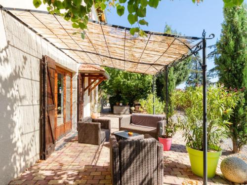 une pergola sur une terrasse avec des chaises et une table dans l'établissement Countryside holiday home with pool, à Renaison